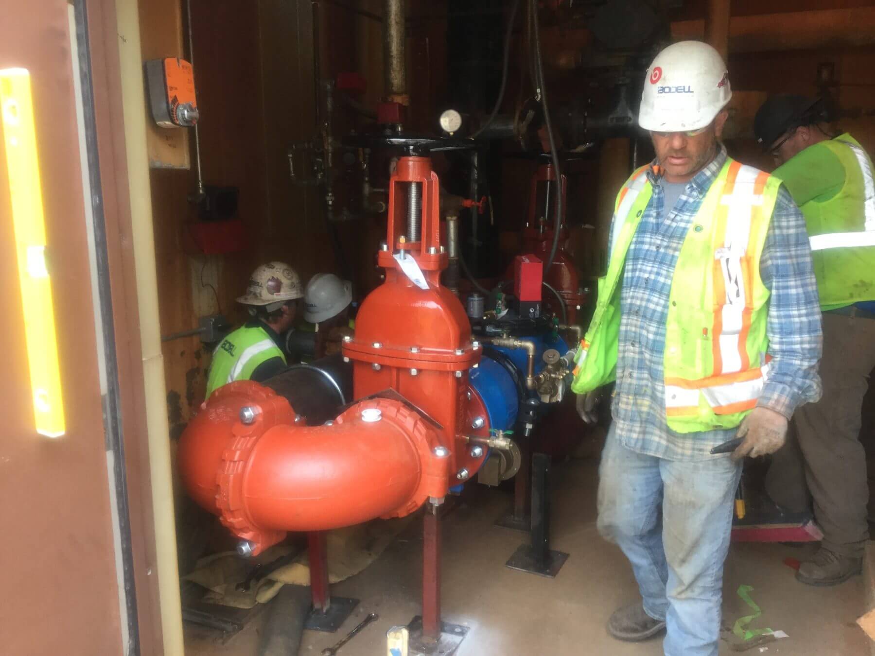 Bodell Workers Setting Valve Indoors