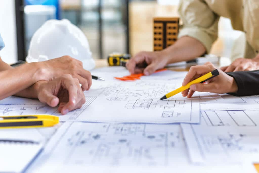 Image of team engineer checks construction blueprints on new project with engineering tools at desk in office.